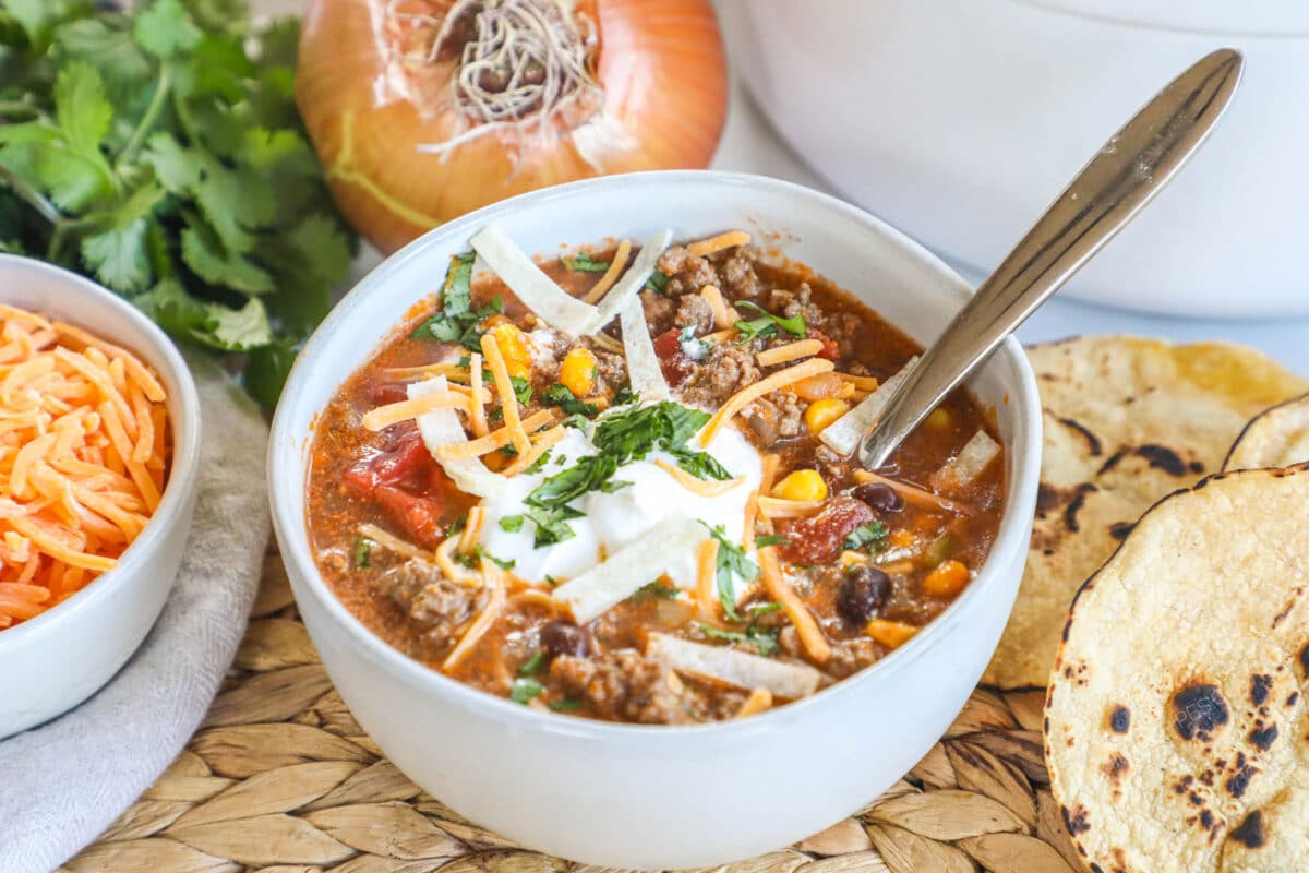 Beef enchilada soup in a white bowl with a spoon