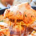 cheese pull image of ravioli being taken out of a skillet.