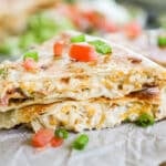 2 chicken bacon ranch quesadilla stacked on a wooden cutting board