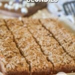 Cinnamon streusel blondies on parchment paper sliced into bars.