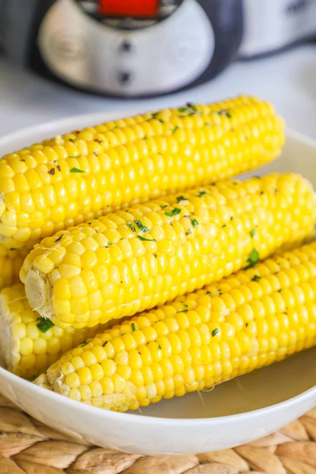 4 ears of corn on a white plate