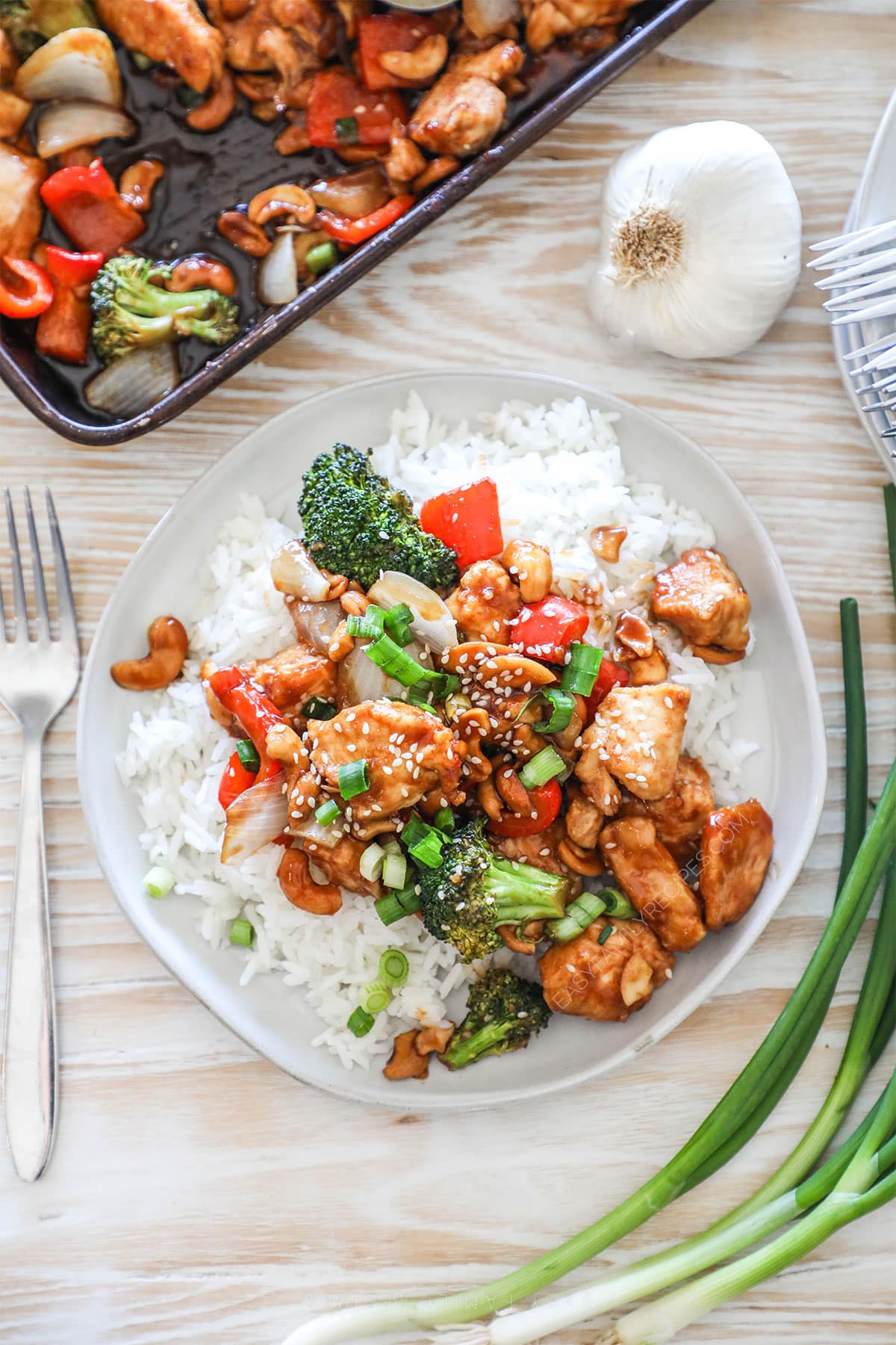 Overhead shot of sheet pan cashew chicken served on a plate with rice.