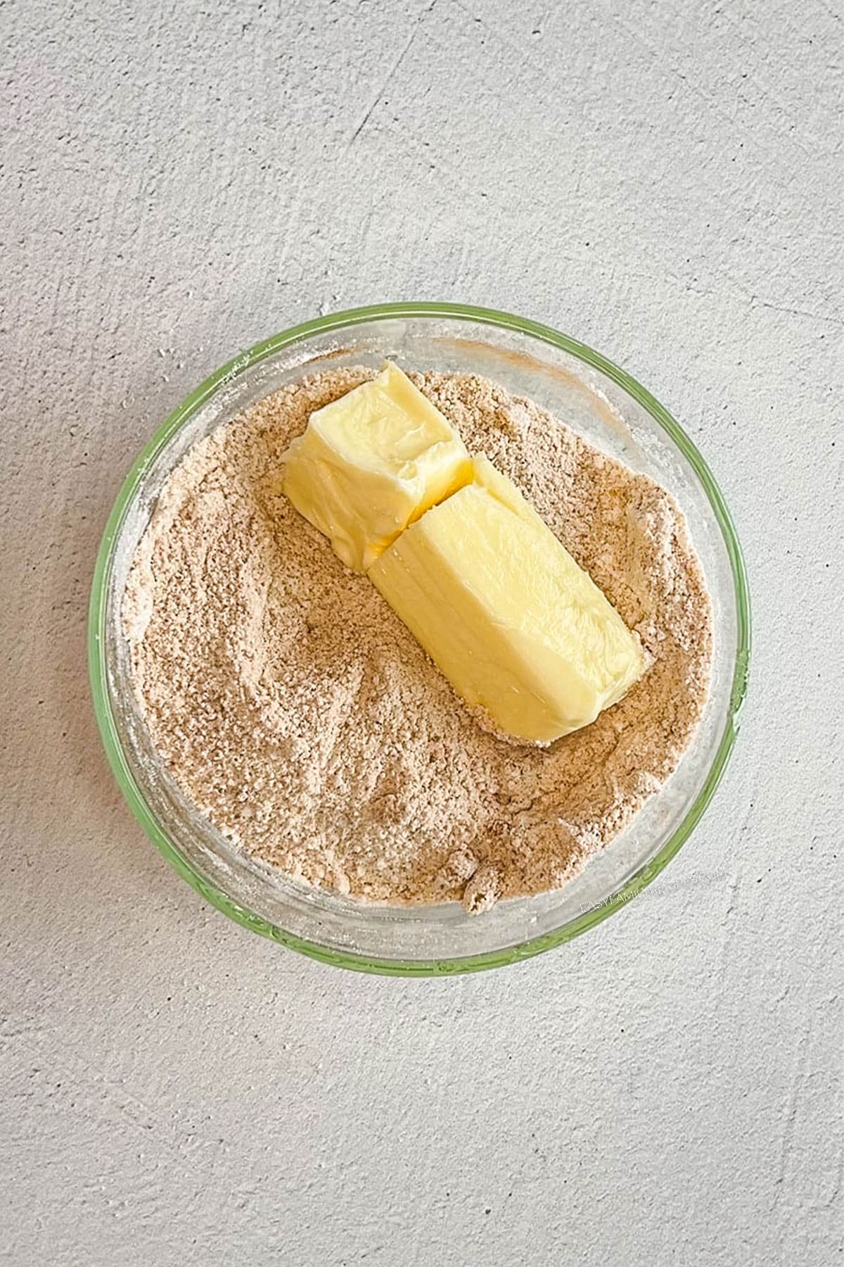Butter in a bowl with granulated and brown sugar.