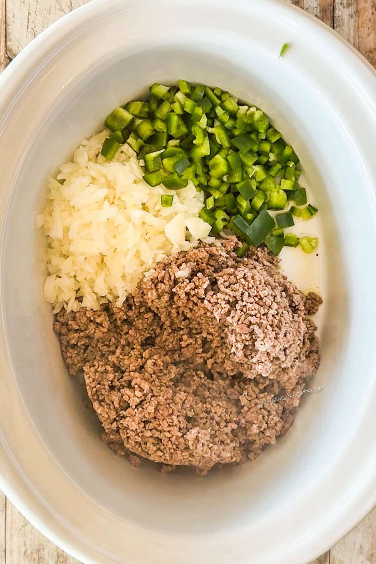 How to make Crockpot Taco Soup Step 1: To the slow cooker, add the ground beef, chopped onion and green bell pepper