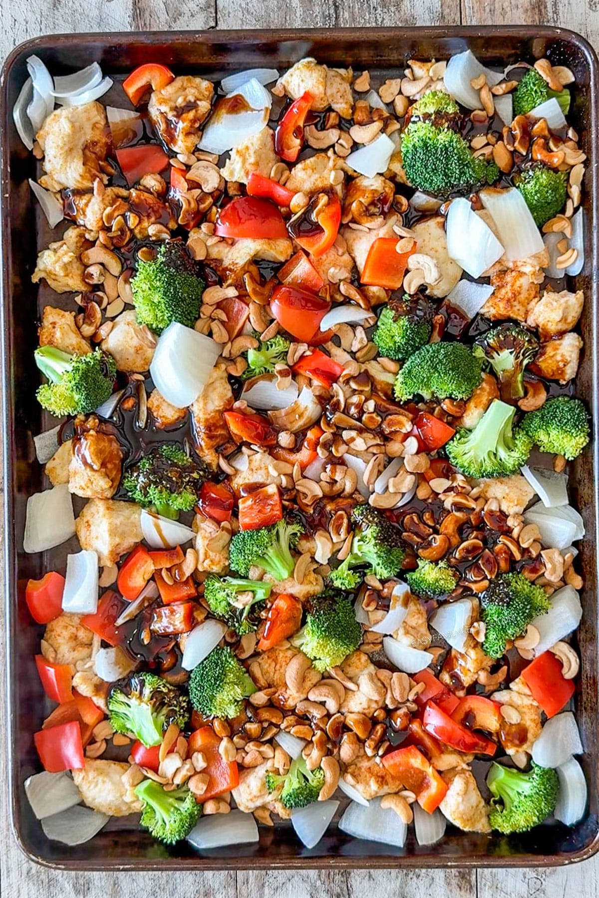 Cashews and the sauce added to the top of the sheet pan chicken.