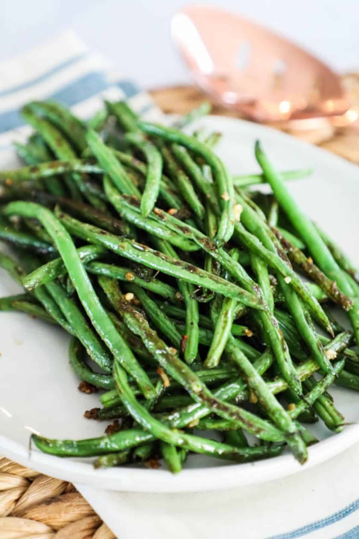 a white plate with a serving of sauteed green beans