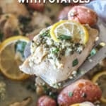 Baked lemon chicken thigh on a spatula hovering over the rest of the chicken.