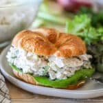 a croissant turkey salad sandwich on a plate.