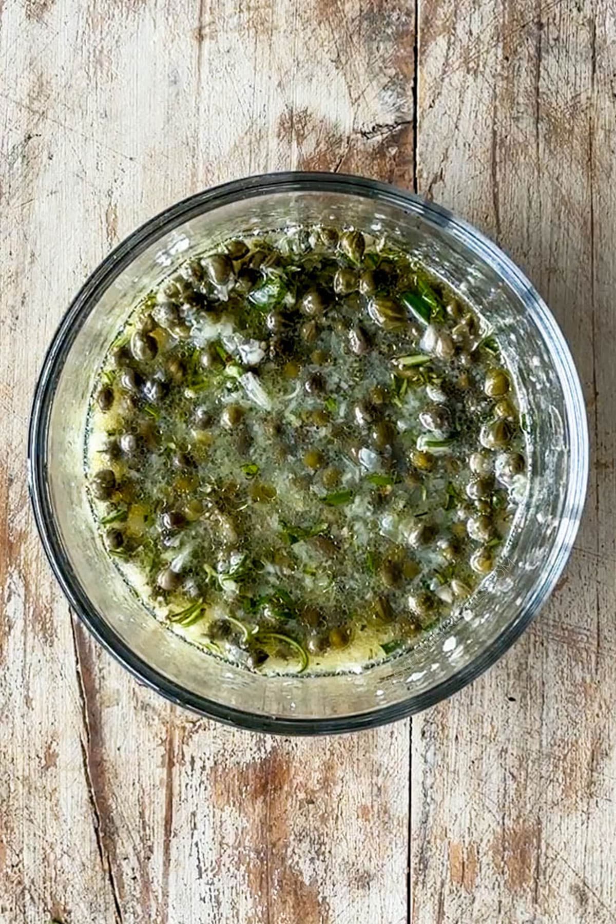 Lemon caper sauce mixed in a glass bowl.