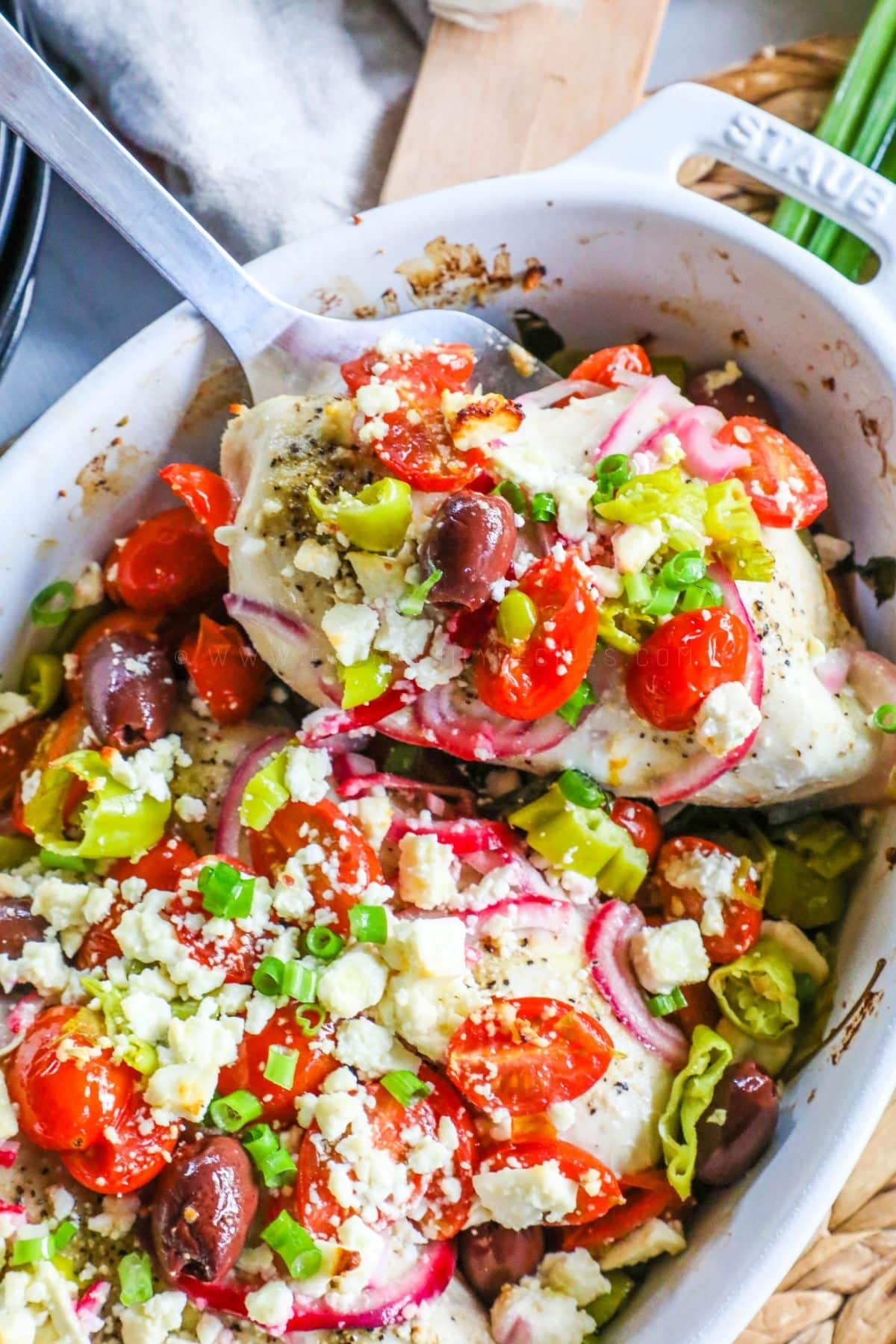 baked greek chicken in a white casserole dish