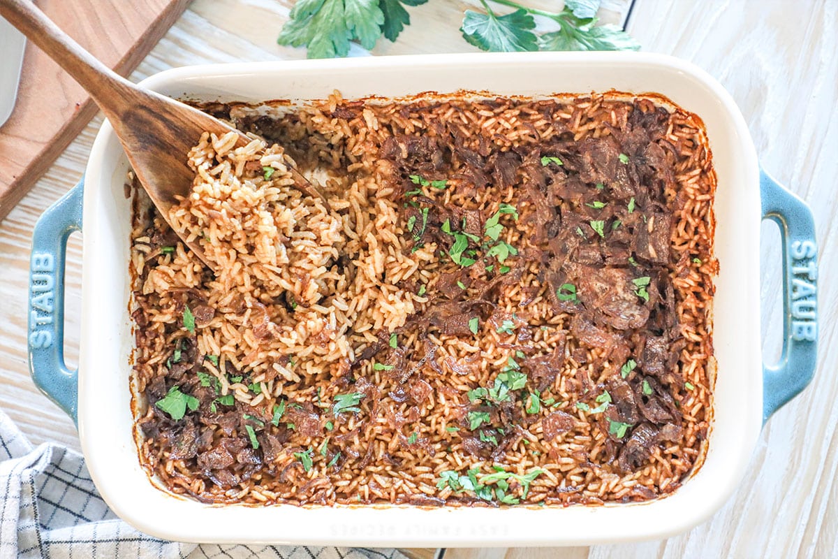 finished stick of butter rice in a dish with a wooden spoon.