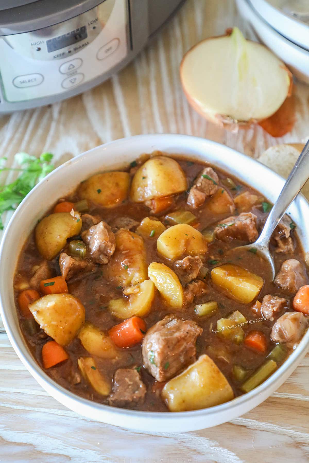 cooked slow cooker beef stew in white bowl with spoon