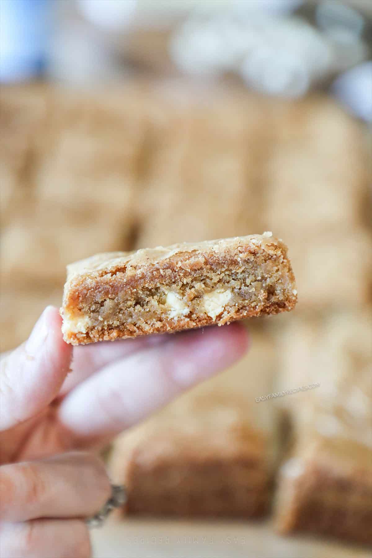 cut square of brown butter blondies held in hand