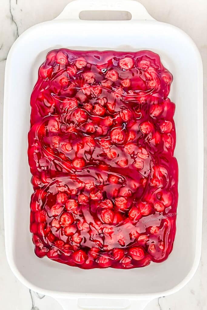 cherry pie filling in the bottom of a baking dish.
