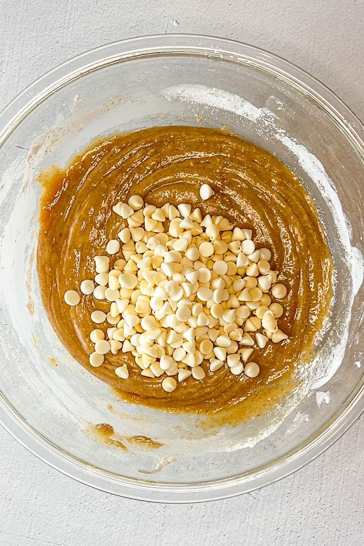 glass bowl of brown butter blondie batter with white chocolate chips poured in