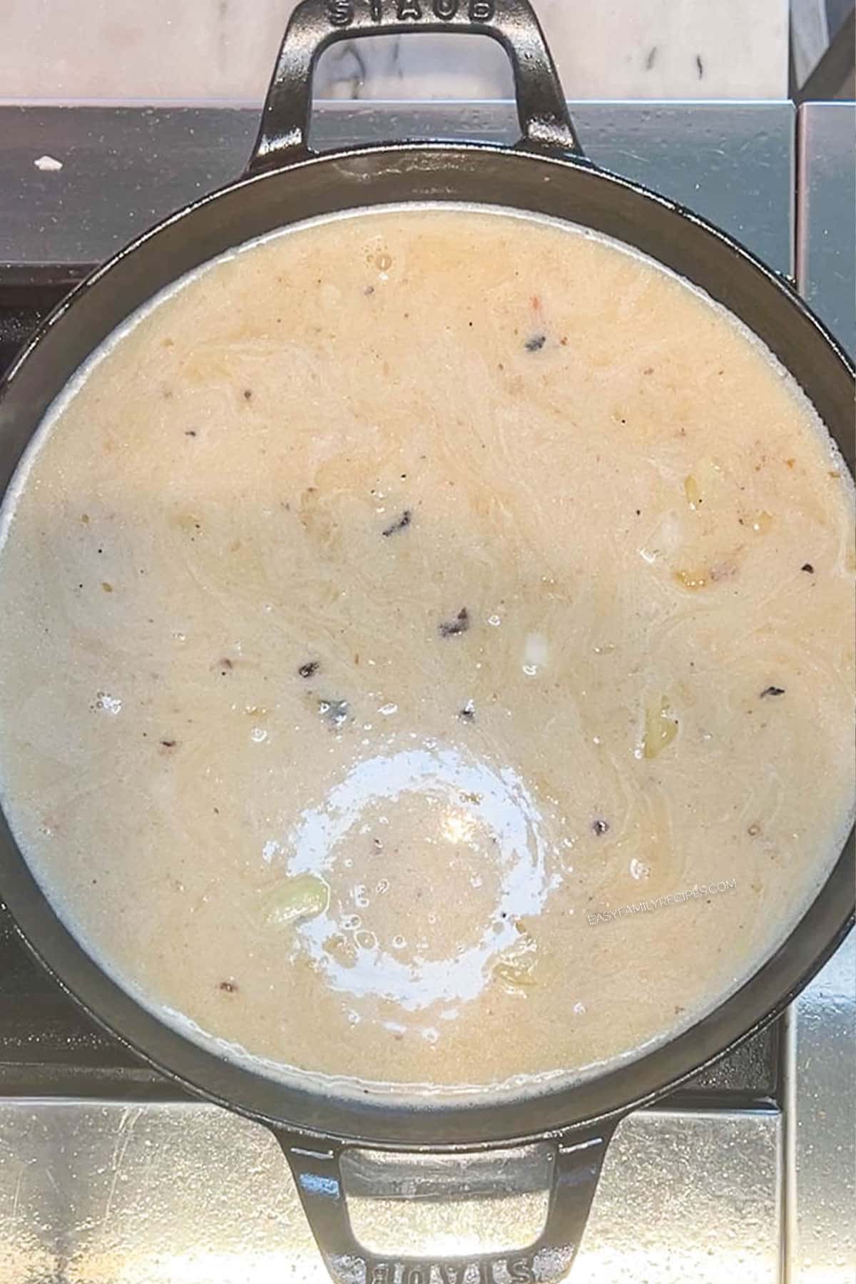 Milk, Boursin and heavy cream added to the risotto in a skillet.