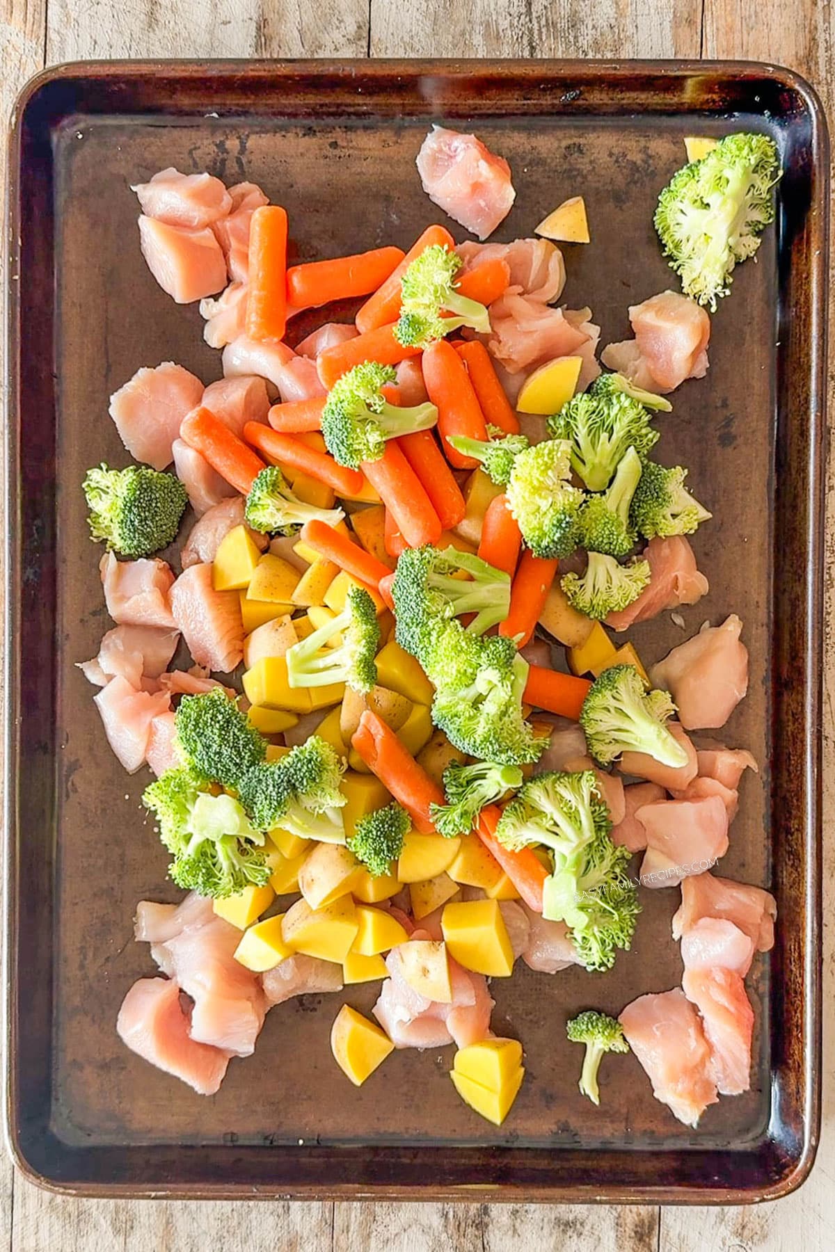 cubed chicken and veggies on a sheet pan.