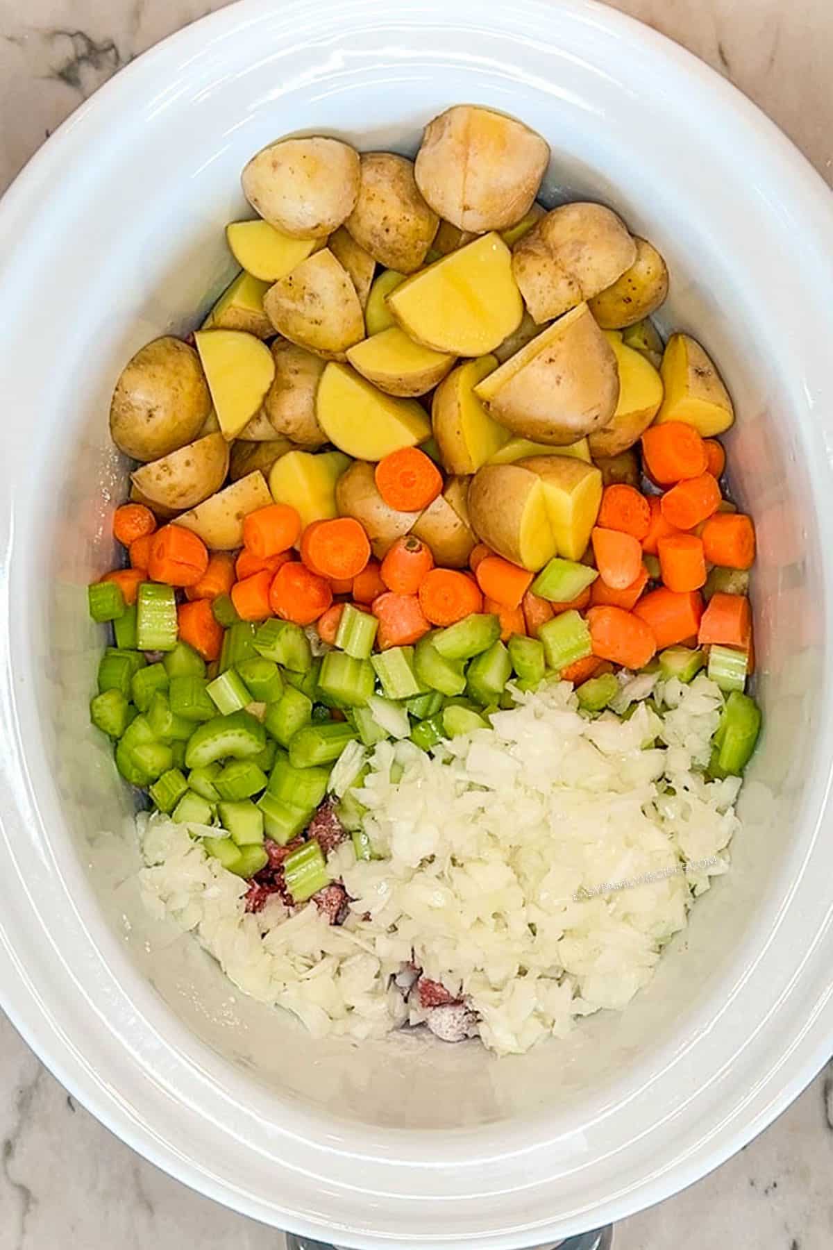 uncooked ingredients in slow cooker beef stew before it has simmered
