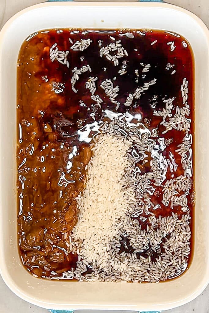 rice, soup, and broth in a baking dish.