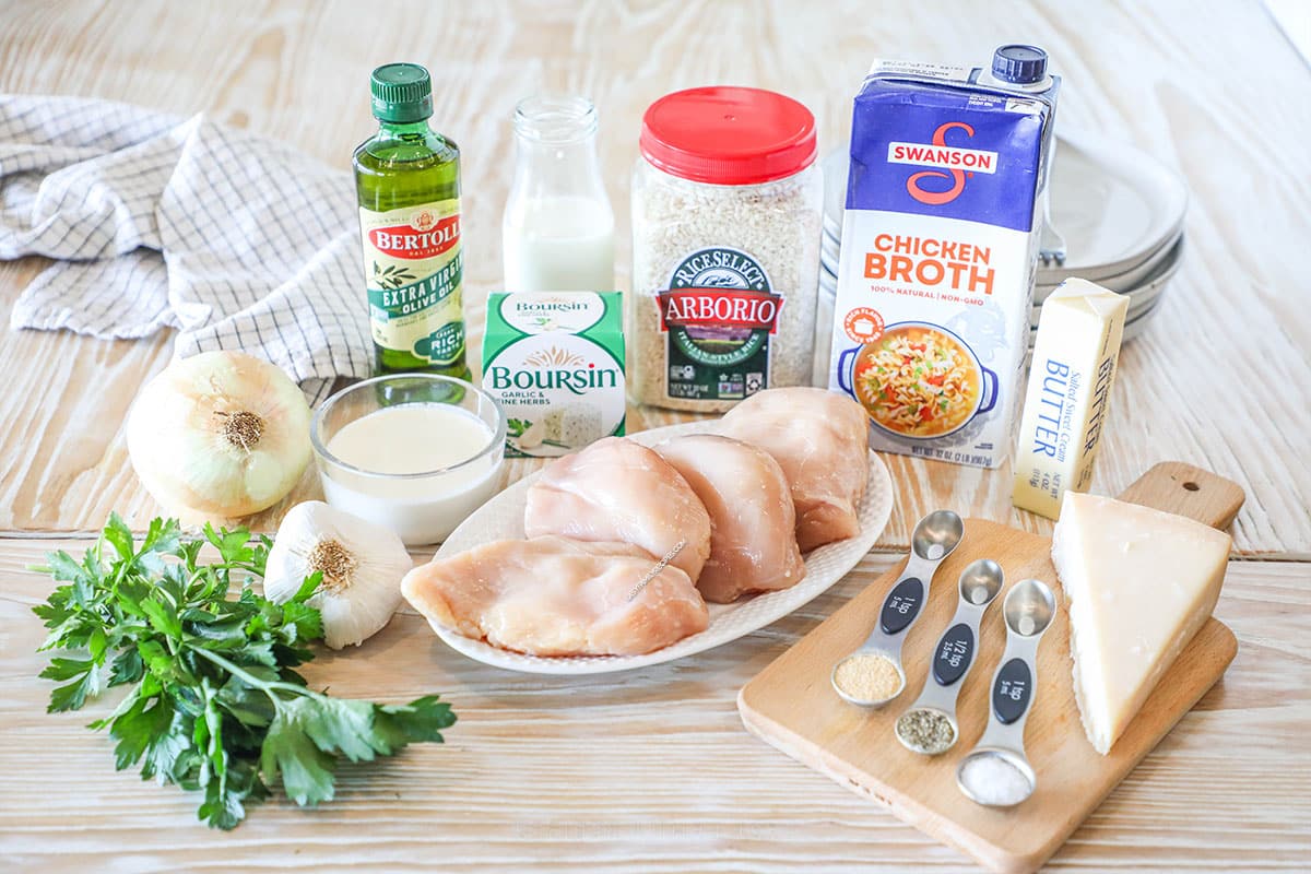 Ingredients needed to make one pan Boursin chicken risotto on a wooden background.
