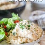 Side view of Boursin chicken risotto served on a plate with a salad.