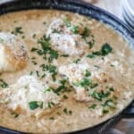 One pan Boursin chicken risotto in a cast iron skillet garnished with parsley.