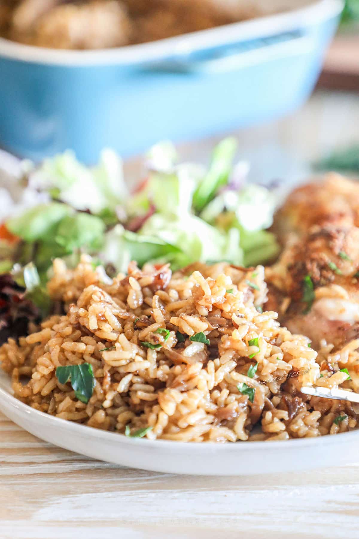 a large helping of stick of butter rice on a plate with a side salad.