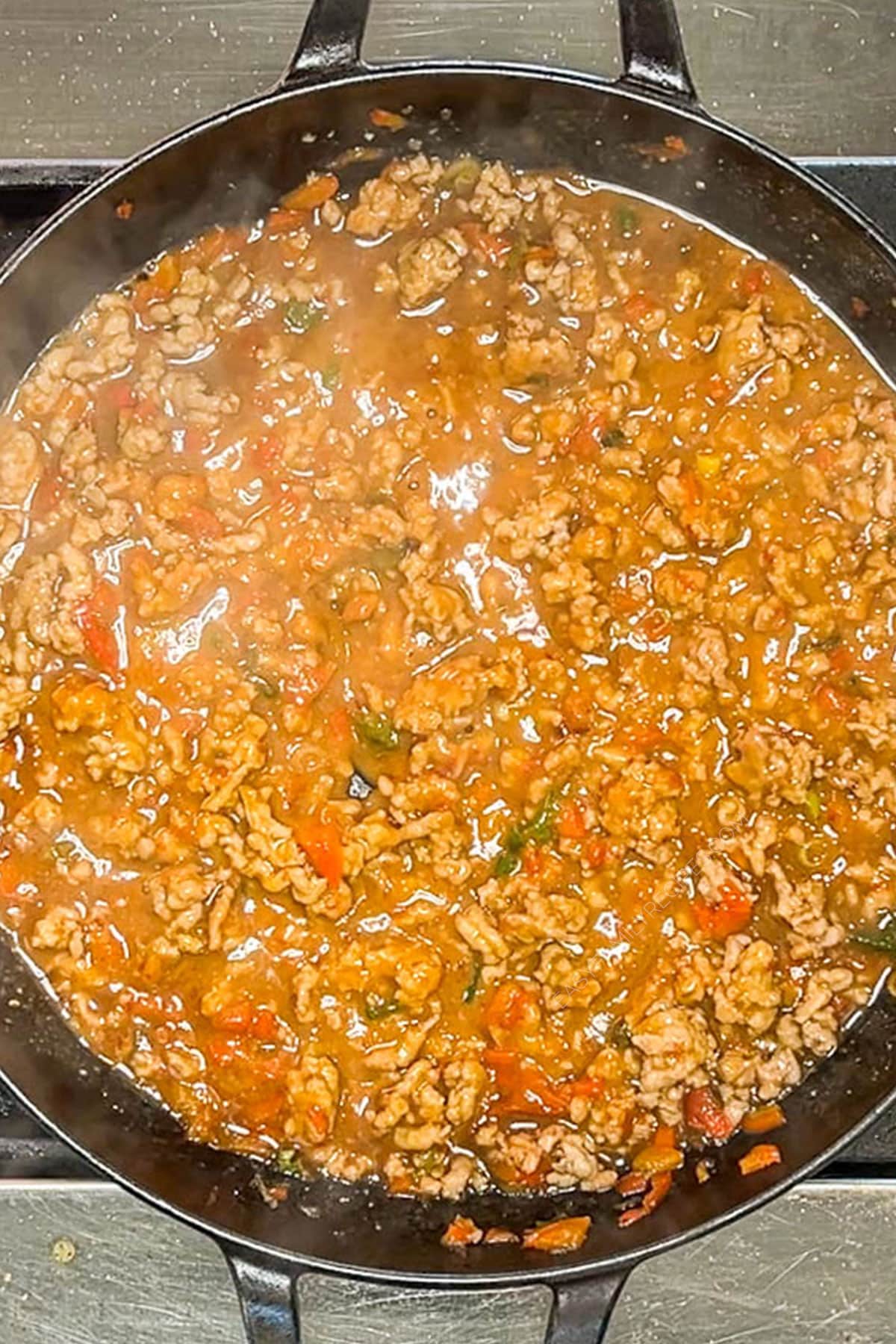 Sauce ingredients added the ground pork in a skillet before noodles are added.