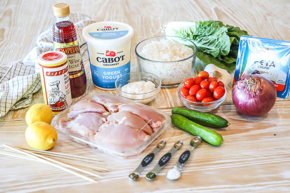 Ingredients needed to make chicken gyro bowls- wooden background