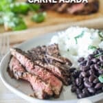 cilantro lime carne asada on a plate with black beans and rice.