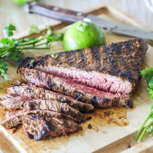 cooked cilantro lime carne asada sliced on a cutting board.