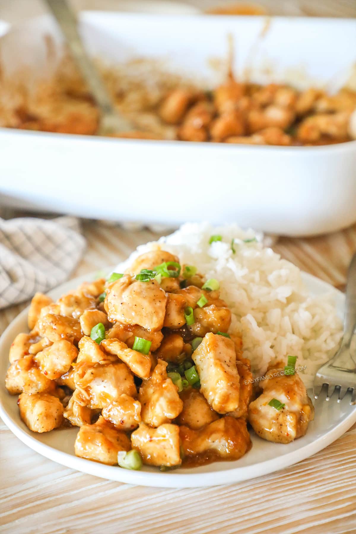 Oven baked orange chicken served on a plate with rice.