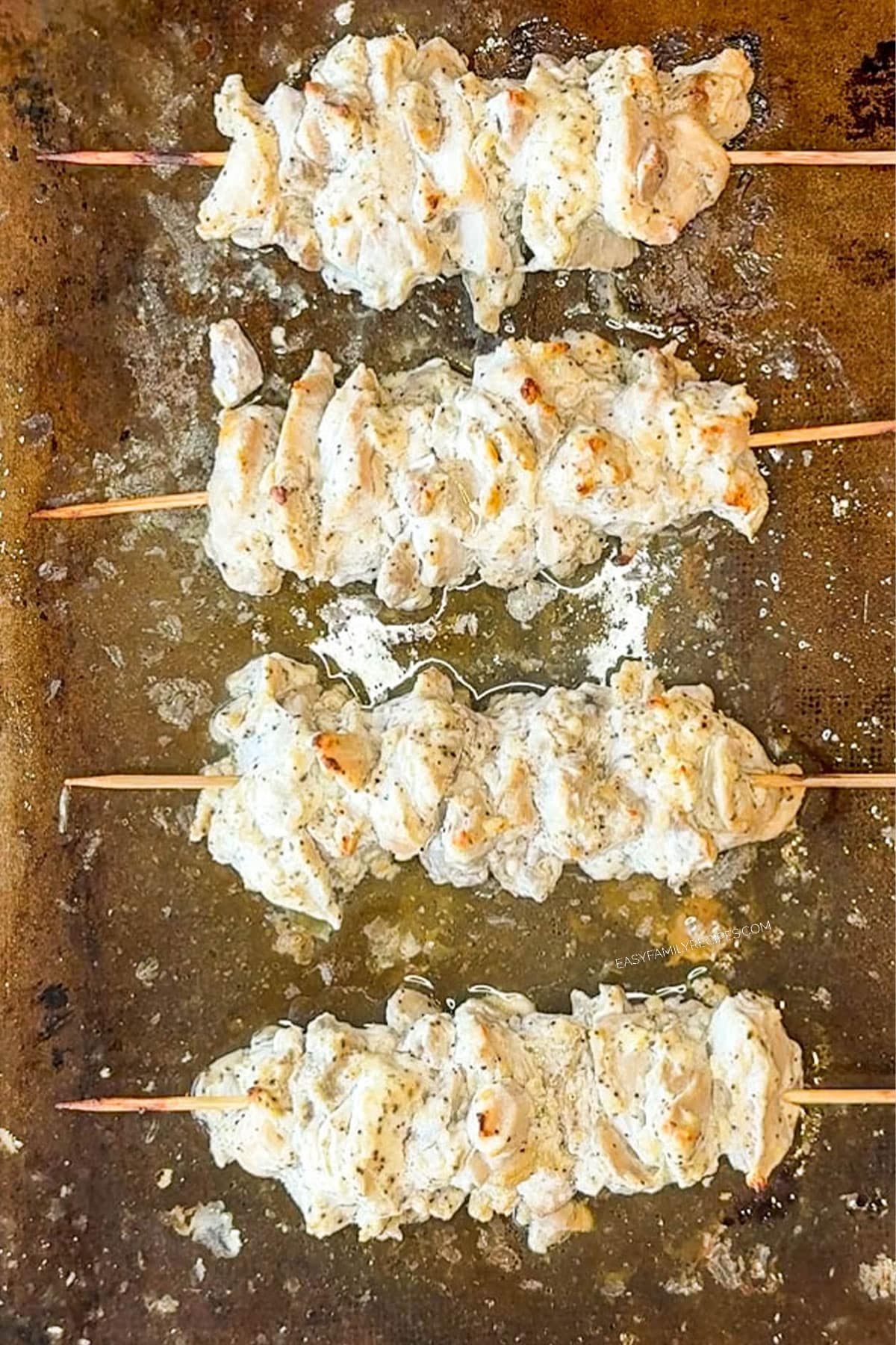 chicken gyro skewers on sheet pan before cooking
