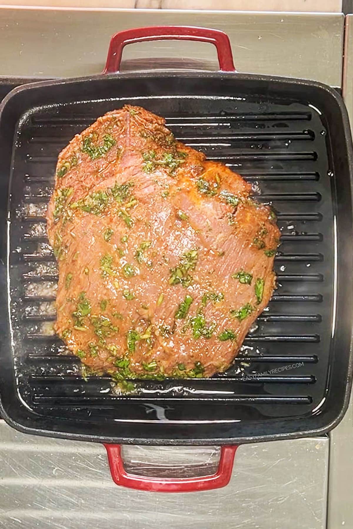 flank steak being grilled on a grill pan.