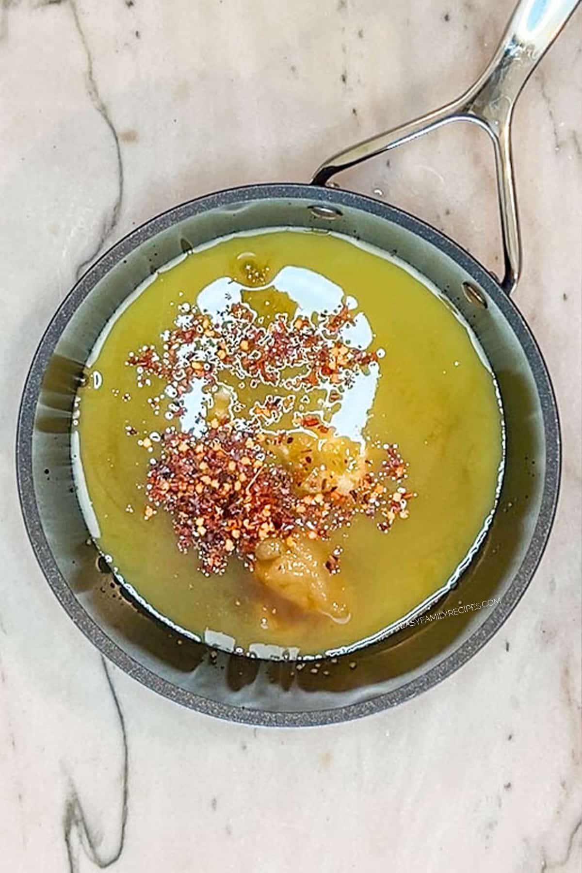 Ingredients for orange chicken sauce in a saucepan before being mixed together.