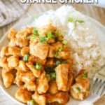 Oven baked orange chicken served on a plate with a side of rice.
