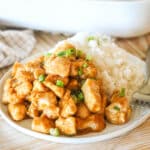 Oven baked orange chicken on a plate with a side of white rice.