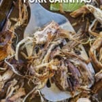 Crockpot Pork Carnitas recipe prepared and spread on a sheet pan to crisp, lifted with a spatual
