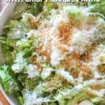 above image of caesar salad topped with parmesan and breadcrumbs.