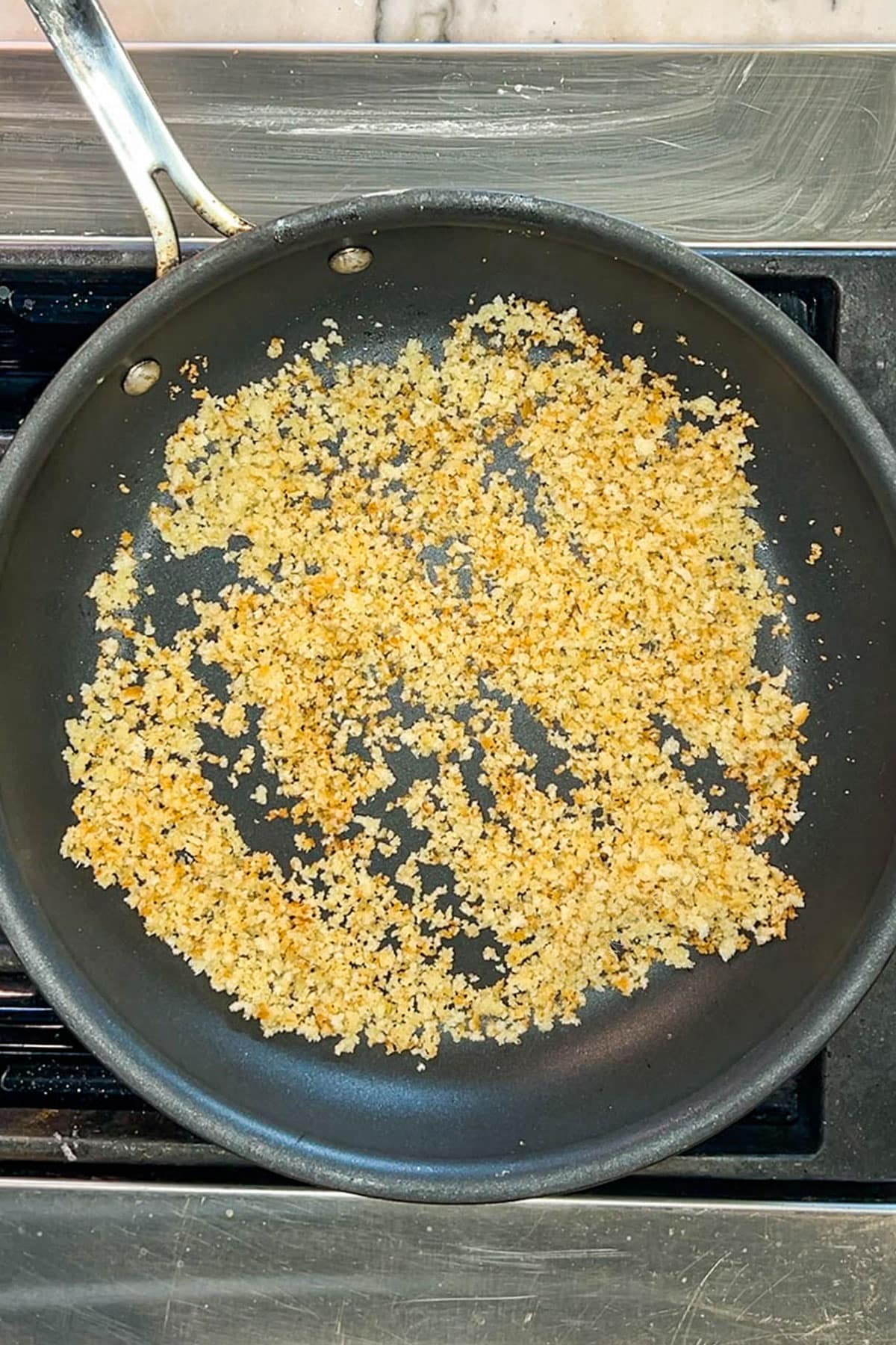breadcrumbs being toasted in a skillet.
