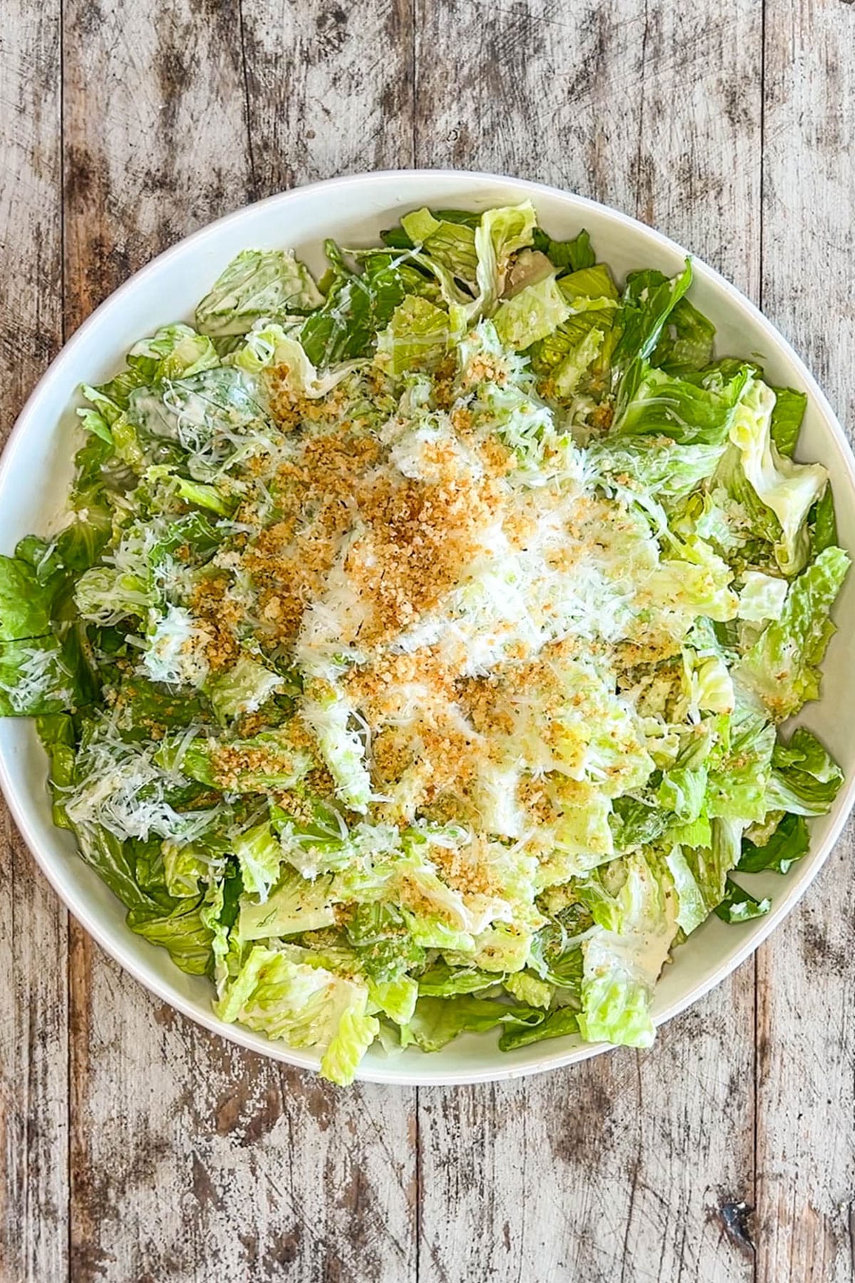 above image of caesar salad with crispy garlic panko on top.