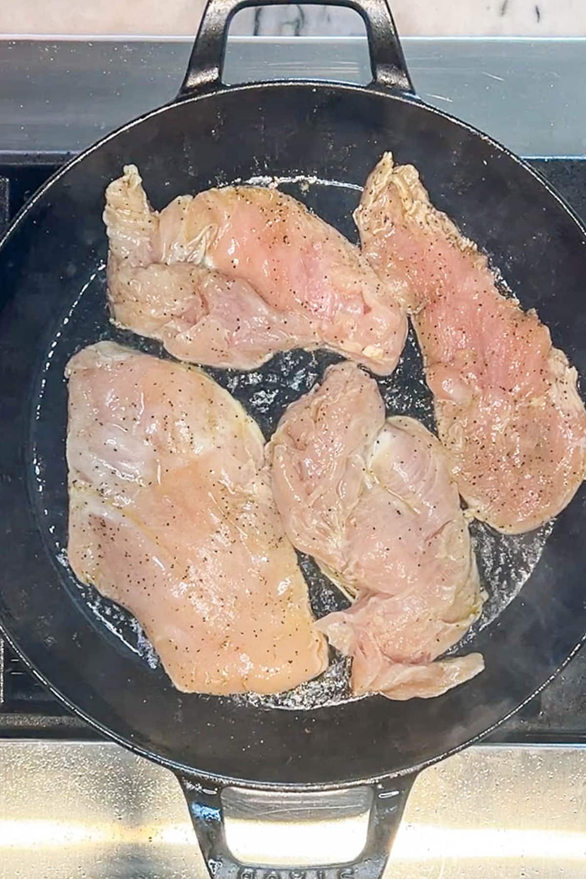Chicken cutlets being cooked in a skillet