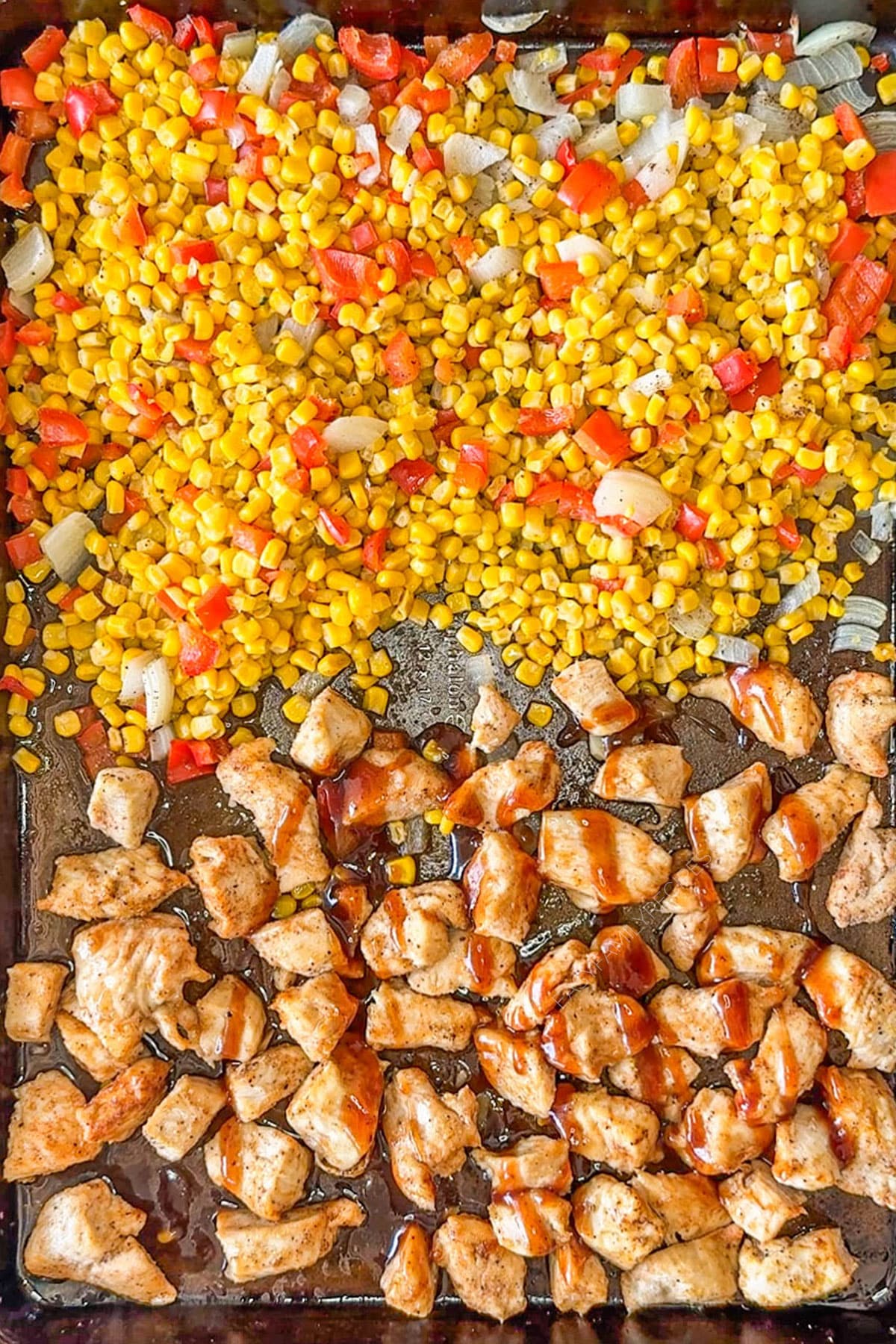 Baked chicken and butter corn with honey BBQ glaze drizzled on top of the chicken.