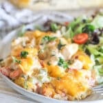 Portion of king ranch chicken casserole served on a plate with a side salad.