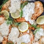 Lemon Feta Chicken in a large skillet, topped with creamy feta mixture, lemon slices and parsley