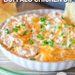 a serving dish filled with cheesy chicken dip.