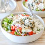 Close up of a Mediterranean meatball bowl with rice, veggies, meatballs and a drizzle of sauce.
