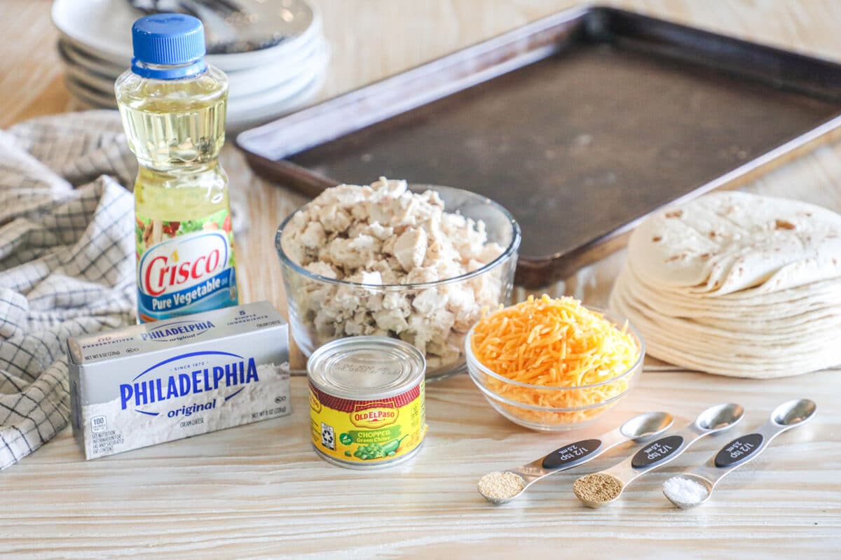 Ingredients needed to make Baked Chicken Taquitos on a wooden background