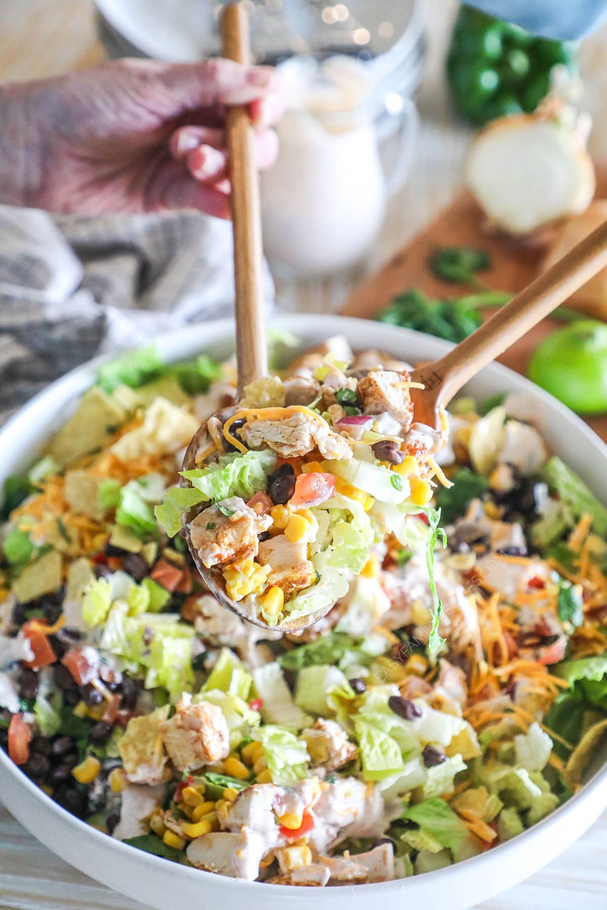 a Mexican chicken salad being served with salad tongs.
