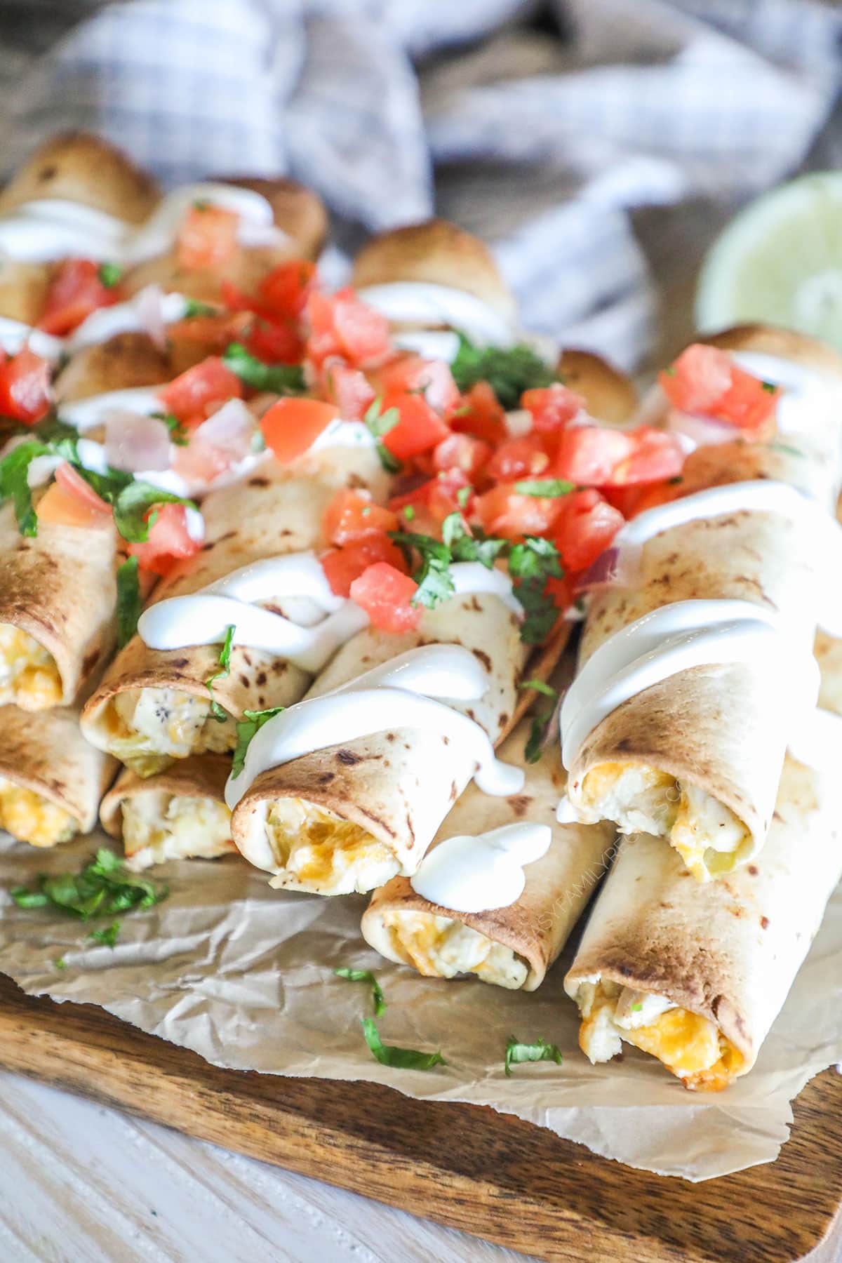 Close up of Baked Chicken Taquitos with toppings including pico and sour cream